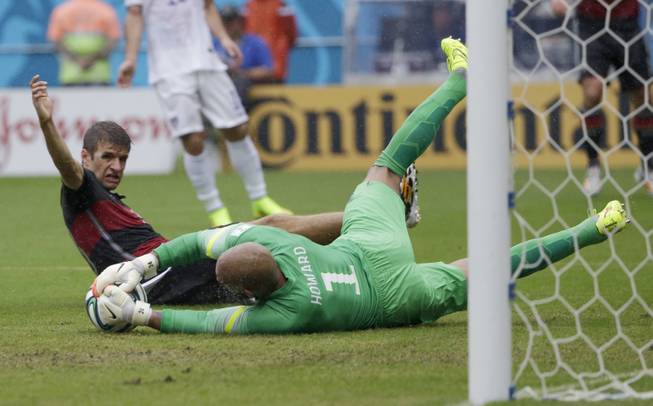 United States' goalkeeper Tim Howard dives to make a save on Germany's Thomas Mueller during the group G World Cup soccer match between the USA and Germany at the Arena Pernambuco in Recife, Brazil, Thursday, June 26, 2014.