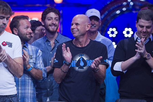Poker players, including Cirque du Soleil cofounder Guy Laliberte, center, applaud during opening ceremonies before the start of the Big One for One Drop, a $1,000,000 buy-in No-Limit Hold'em charity poker tournament, at the Rio Sunday, June 26, 2014. The $1 million buy-in is the largest ever for a poker event. Proceeds support One Drop projects in countries experiencing serious difficulties caused by inadequate access to water.