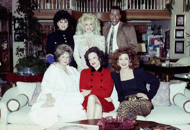 Actor Meshach Taylor, top right, joins the cast of "Designing Women" and special guest Dolly Parton, top center, for the taping of the New Year's Day episode of the show Dec. 8, 1989, in Burbank, California. Taylor's agent says the actor, who appeared in the hit sitcoms "Designing Women" and "Dave's World" died of cancer on Saturday, June 28, 2014, at his home in Los Angeles. He was 67.