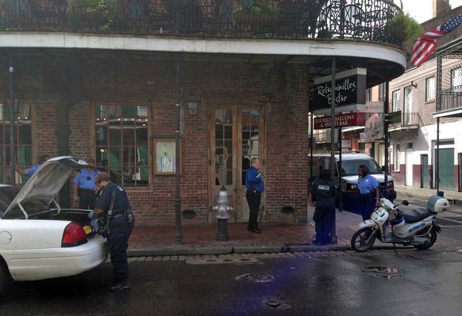 Authorities continue working the scene along Bourbon Street after a shooting, early Sunday, June 29, 2014, in New Orleans. Nine people were shot on Bourbon Street in New Orleans' celebrated French Quarter, leaving at least one person in critical condition.