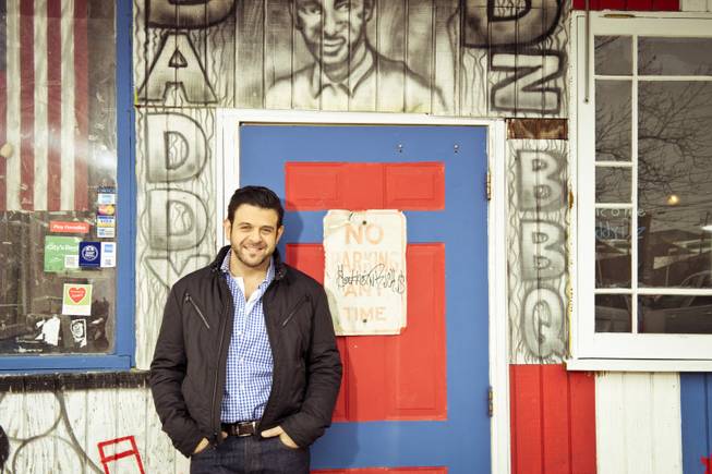 This undated photo provided by the Travel Channel shows host Adam Richman of the new series "Man Finds Food" in Atlanta. The channel said Tuesday, July 1, 2014, that Richman's show has been postponed indefinitely but didn't explain why. "Man Finds Food" was to debut Wednesday.