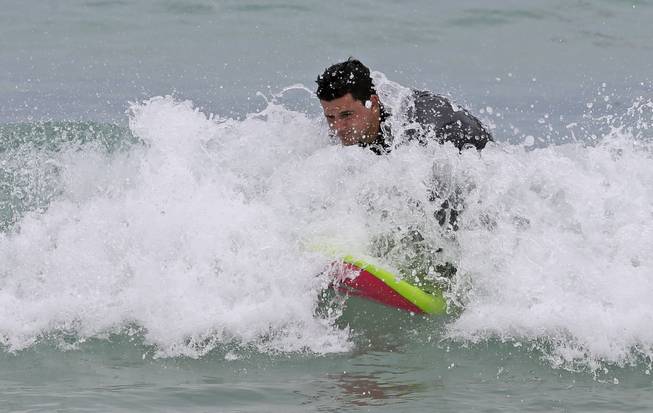 Stefano Campodonico, of Miami, body boards a small wave in Miami Beach, Fla., Tuesday, July 1, 2014. Tropical Storm Arthur has formed off the central Florida coast, becoming the first named storm of the Atlantic hurricane season. 