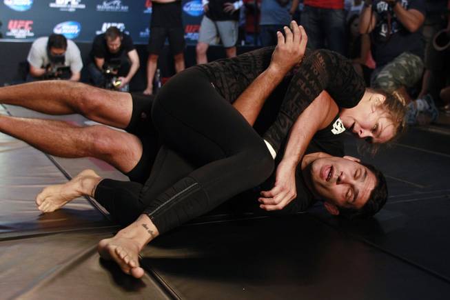 Ronda Rousey grapples with Justin Flores during the open workout for UFC 175 Wednesday, July 2, 2014 at the Fashion Show Mall.