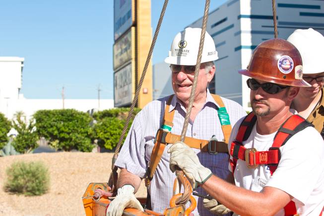 David Siegel, founder and CEO of Westgate Resorts, and Aaron Neal of Yesco prepare to be hoisted more than 200 feet to remove the LVH letters off the main sign of Westgate's newly purchased property Tuesday, July 1, 2014.