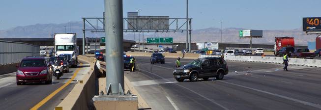 Traffic flows around as Las Vegas Metro Police continue to work the scene of a fatal car crash on the I-15 just north of the I-95 interchange on Wednesday, July 2, 2014.