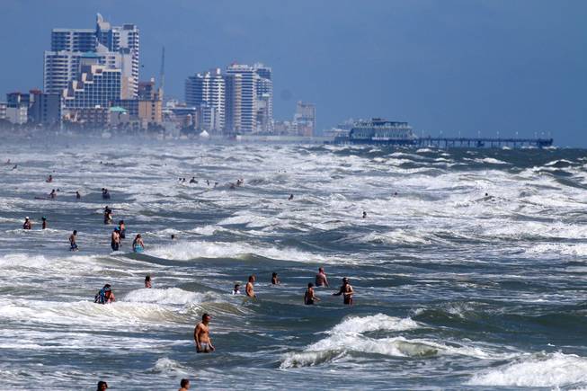 People deal with the high surf and currents off Daytona Beach generated by Tropical Storm Arthur on Tuesday, July 1, 2014.