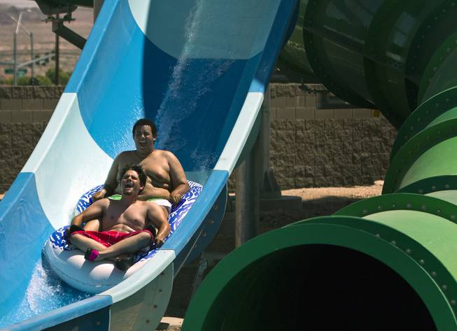 Jimmy Cyborski and Ian Evans of Las Vegas complete the Point panic slide during opening day at Cowabunga Bay on Friday, July 4, 2014.  L.E. Baskow