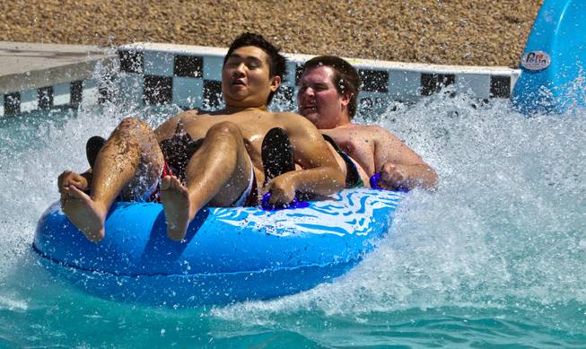 Elysian Fields and Andrew Huskey of Las Vegas complete the Point panic slide during opening day at Cowabunga Bay on Friday, July 4, 2014, in Henderson.