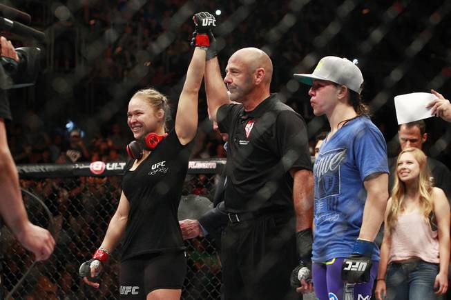 Ronda Rousey has her arm raised after defeating Alexis Davis with a TKO during their fight at UFC 175 at the Mandalay Bay Events Center Saturday, July 5, 2014.