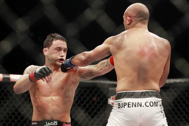 Frankie Edgar is hit by a left from B.J. Penn during their fight at "The Ultimate Fighter" 19 finale Sunday, July 6, 2014 at the Mandalay Bay Events Center.