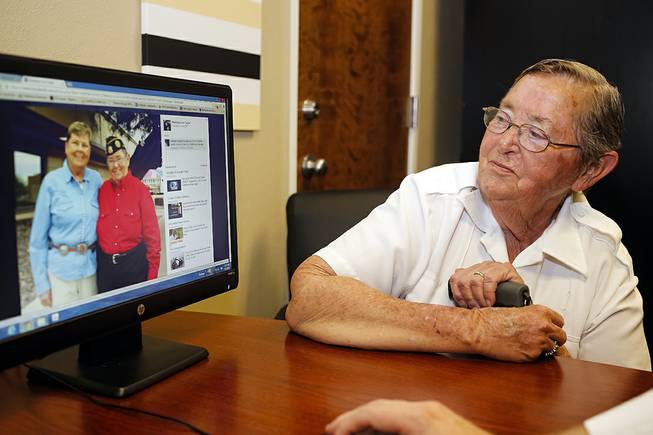 Madelynn Taylor, 74, looks at a 2011 photo of herself (in red) with her wife Jean Mixner, in Boise, Idaho on July 7, 2014. Taylor has filed a lawsuit seeking the right to have her deceased wife interred with her at the Idaho State Veterans Cemetery.