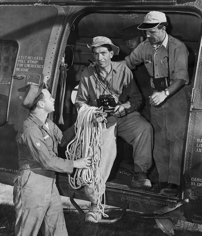 Two members of a Swiss mountain climbing team, who arrived in Grand Canyon, Arizona to assist in recovering bodies of victims of a UAL plane crash in this canyon on June 30, are handed a coil of rope by Spc/3 Robert Lee as they leave by helicopter for the wreck scene, July 6, 1956. From left are Lee, Anton Spinas, who will direct the team, and Max Stampfli, Swiss pilot. 