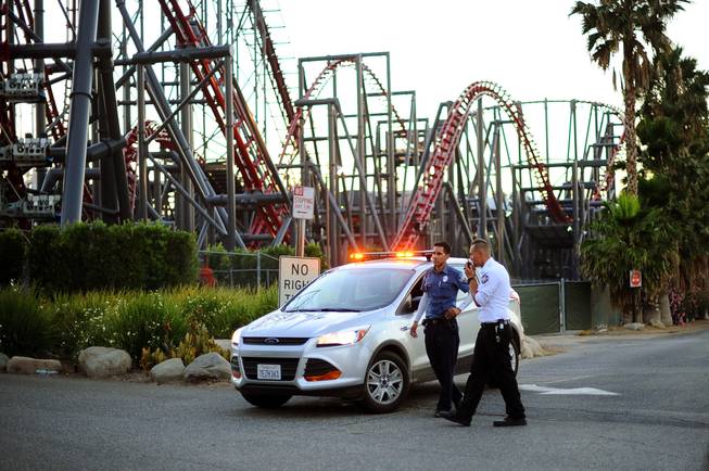 Members of the Six Flags Magic Mountain amusement park security staff monitor the situation at the exit of the park after riders were injured on the Ninja coaster Monday, July 7, 2014, in Valencia, Calif.