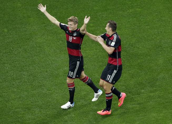 Germany's Toni Kroos, left, celebrates scoring his side's third goal with teammate Miroslav Klose during the World Cup semifinal soccer match between Brazil and Germany at the Mineirao Stadium in Belo Horizonte, Brazil, Tuesday, July 8, 2014. 