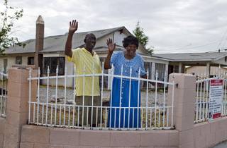 Stanton Wilkerson and Katherine Duncan wave to Metro Police Officer Gordie Bush as they stand outside the Harrison House on Wednesday, July 9, 2014. The home is where black entertainers and others stayed when Jim Crow-like laws ruled Las Vegas.