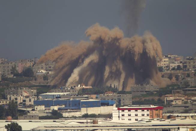 Smoke and debris rise after an Israeli strike on the Gaza Strip seen from the Israeli side of the Israel Gaza Border, Wednesday, July 9, 2014.