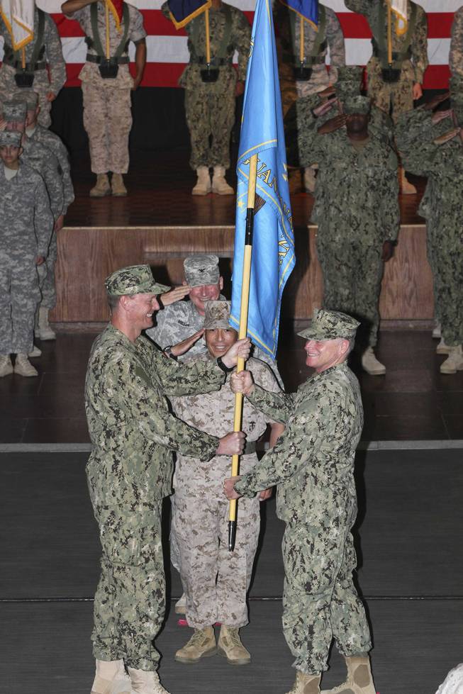 Rear Adm. Richard Butler hands the colors to Rear Adm. Kyle Cozad during a change-of-command ceremony at Joint Task Force Guantanomo on Thursday, July 10, 2014. Cozad, a Las Vegas native and 1981 graduate of Chaparral High School, took over command of the base in Cuba from Butler.