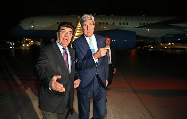 U.S. Secretary of State John Kerry, right, talks with Afghanistan's Ministry of Foreign Affairs chief of protocol Ambassador Hamid Siddiq, as Kerry arrives at Kabul International airport in Kabul, Friday July 11, 2014. 