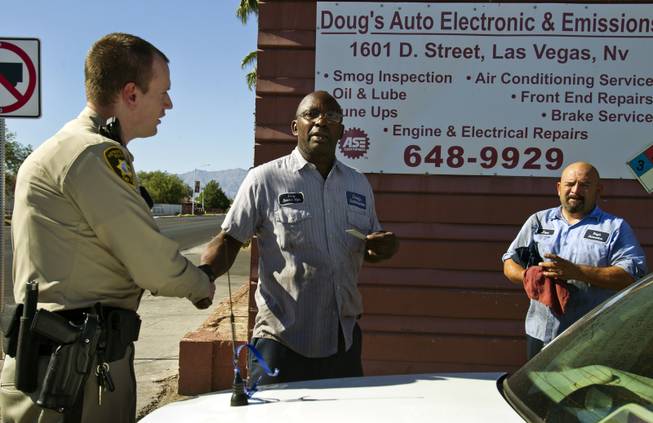 Metro Police Officer Gordie Bush visits with Doug's Auto Electric & Emissions about a possible issue on his property during neighborhood patrol in the Bolden Area Command on Thursday, July 3, 2014.