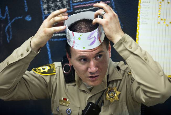 Metro Police Officer Gordie Bush joins the kids in making paper and crayon hats at the Sherman Gardens Youth Center on Thursday, July 3, 2014.