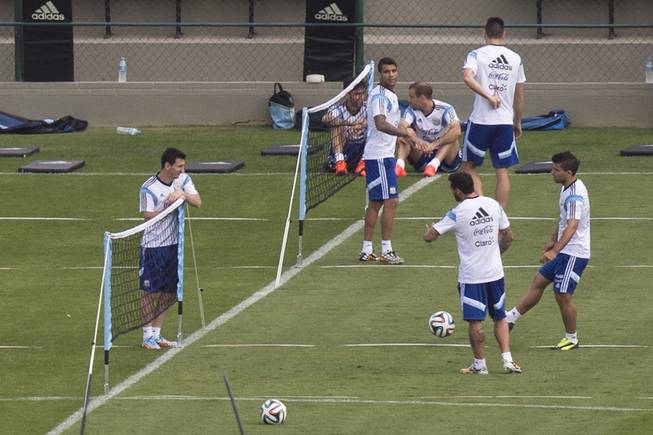 Argentina's Lionel Messi, left, talks to teammates Sergio Aguero, right, and Ezequiel Lavezzi, second right, during a training session in Vespesiano, near Belo Horizonte, Brazil, Friday, July 11, 2014. On Sunday, Argentina faces Germany for the World Cup final soccer match in Rio de Janeiro.