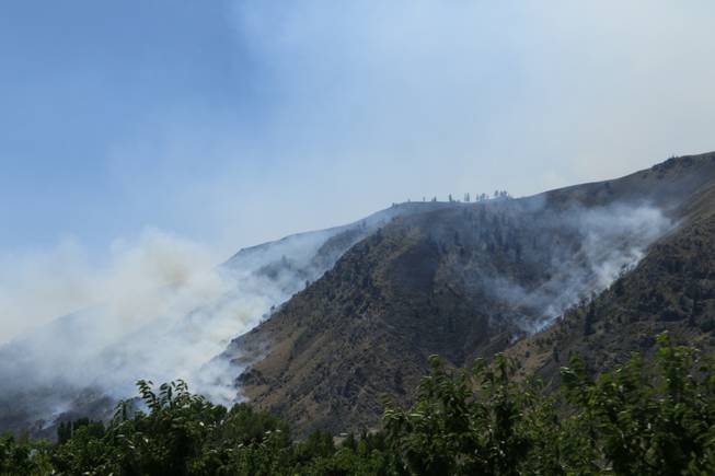 Smoke rises from the area of a wildfire near Entiat, Wash., on Friday, July 11, 2014. Several hundred firefighters worked Friday to contain the fire, which has burned grass and brush across 32 square miles in central Washington. 