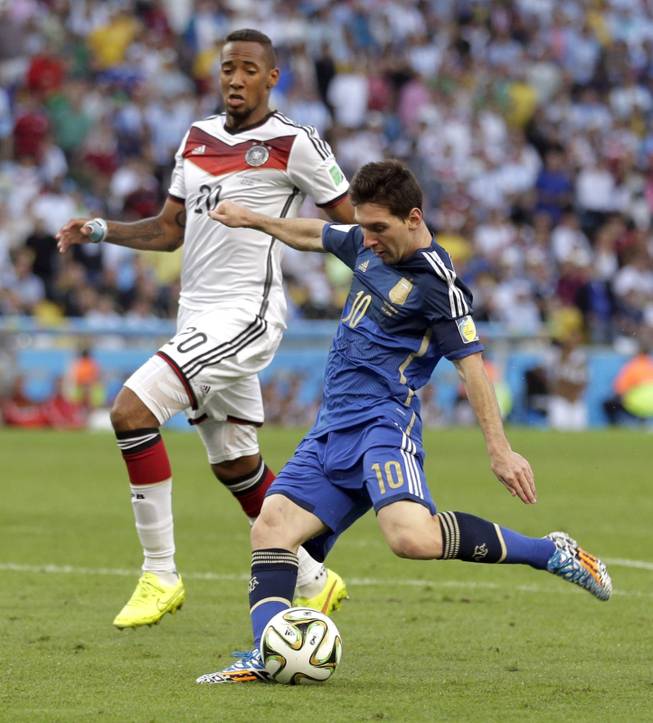 Germany's Jerome Boateng watches as Argentina's Lionel Messi takes a shot on goal during the World Cup final soccer match between Germany and Argentina at the Maracana Stadium in Rio de Janeiro, Brazil, Sunday, July 13, 2014.