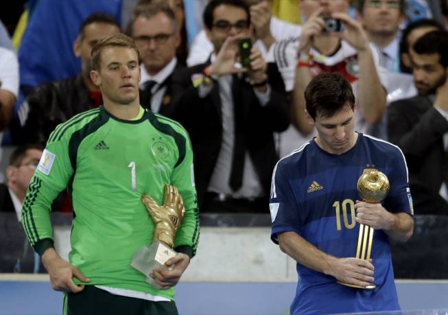 Germany's goalkeeper Manuel Neuer, recipient of the Golden Glove trophy, stands next to Argentina's Lionel Messi after he receive the Golden Ball trophy following Germany's 1-0 victory over Argentina after the World Cup final soccer match between Germany and Argentina at the Maracana Stadium in Rio de Janeiro, Brazil, Sunday, July 13, 2014. (AP Photo/