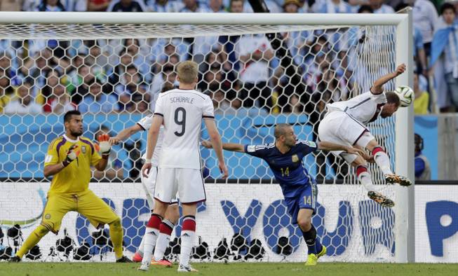 A header from Germany's Benedikt Hoewedes, right, hits the post during the World Cup final soccer match between Germany and Argentina at the Maracana Stadium in Rio de Janeiro, Brazil, Sunday, July 13, 2014. 