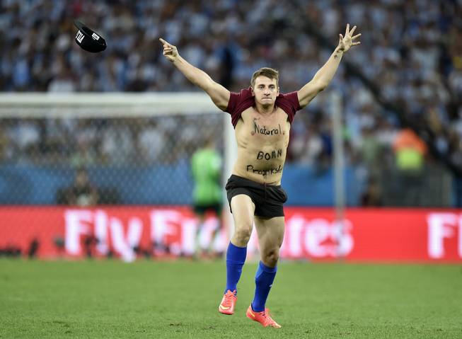 A man runs onto the pitch during the World Cup final soccer match between Germany and Argentina at the Maracana Stadium in Rio de Janeiro, Brazil, Sunday, July 13, 2014.