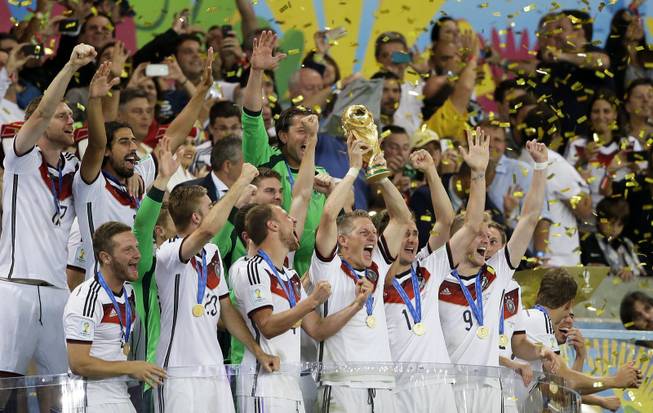 Germany's Bastian Schweinsteiger, center, lifts the trophy amid his teammates after the World Cup final soccer match between Germany and Argentina at the Maracana Stadium in Rio de Janeiro, Brazil, Sunday, July 13, 2014. Germany beat Argentina 1-0 to win the World Cup.