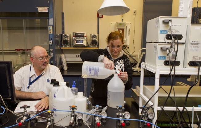 Steve George and Jennifer McCarville conduct fluoride detection tests in water samples at the inorganic lab within the SNWA's massive testing facility out near Lake Mead on Wednesday, July 9, 2014.
