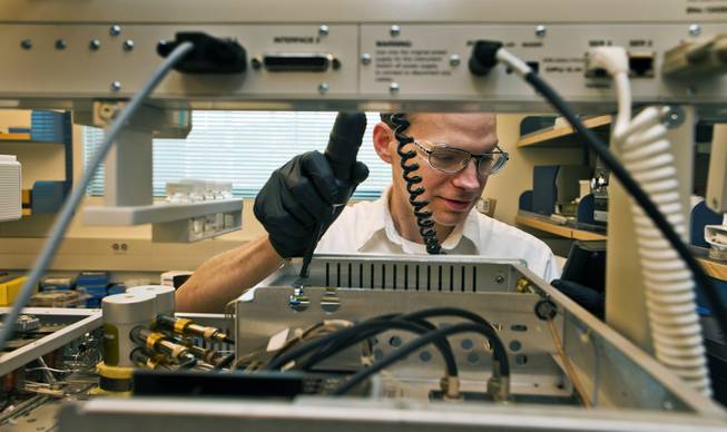 Analytical chemist Matthew Desautel makes a small electrical repair on a piece of equipment in his lab within the SNWA's massive testing facility out near Lake Mead on Wednesday, July 9, 2014.