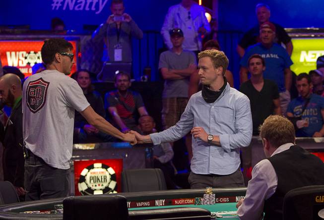 Mark Newhouse, left, shakes hands with Maximilian Senft of Austria after knocking Senft out of the World Series of Poker $10,000 buy-in No-limit Texas Hold 'em main event at the Rio Monday, July 14, 2014.