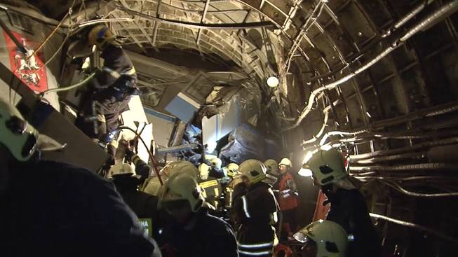 In this frame grab from video provided by the Russian Ministry for Emergency Situations, rescue teams work inside the tunnel in Moscow where a rush-hour subway train derailed Tuesday, July 15, 2014, killing at least 20 people and sending 150 others to the hospital, many with serious injuries, Russian officials said.