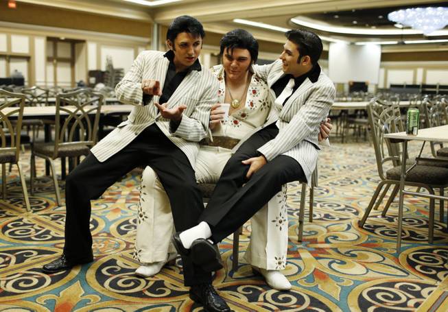 In this July 12, 2014, photo, from left, Daniel Jenkins, Tyler James and Jacob Roman joke around during the Las Vegas Elvis Festival in Las Vegas. The three, along with other Elvis tribute artists, performed in a competition at the convention.