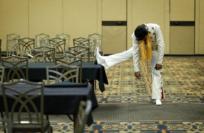 In this July 12, 2014, photo, Elvis tribute artist Joseph Hall, of Branson, Mo., stretches before performing at the Las Vegas Elvis Festival in Las Vegas. Some three dozen Elvis tribute artists took their gyrating hips and curled lips to the stage over the weekend to see who could do the most convincing portrayal.