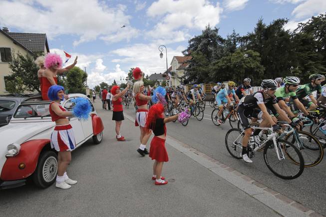 Cheerleaders with a Citroen 2CV classic car greet the pack during the tenth stage of the Tour de France cycling race over 161.5 kilometers (100.4 miles) with start in Mulhouse and finish in La Planche des Belles Filles, France, Monday, July 14, 2014. 