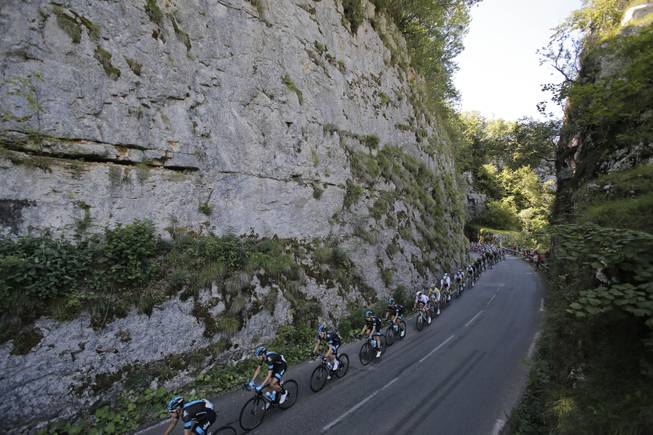 The pack passes during the eleventh stage of the Tour de France cycling race over 187.5 kilometers (116.5 miles) with start in Besancon and finish in Oyonnax, France, Wednesday, July 16, 2014. 