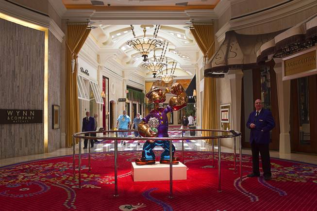 A security officer keeps an eye on the Popeye sculpture in the Wynn Esplanade Thursday, July 17, 2014. The stainless steel sculpture, by American artist Jeff Koons, was purchased at auction for $28.2 million.