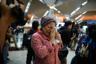 A woman reacts to news regarding a Malaysia Airlines plane that crashed in eastern Ukraine at Kuala Lumpur International Airport in Sepang, Malaysia, Friday, July 18, 2014.  Ukraine said a passenger plane carrying 295 people was shot down Thursday as it flew over the country, and both the government and the pro-Russia separatists fighting in the region denied any responsibility for downing the plane. 