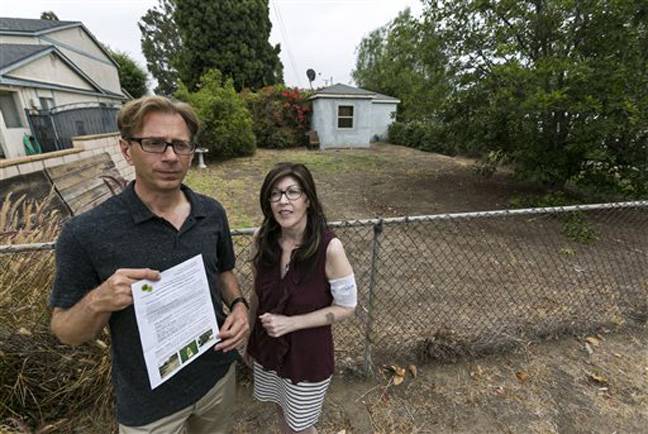 Michael Korte and his wife, Laura Whitne scaled back watering due to drought but received a letter from the city of Glendora warning they could face fines if they don't get their brown lawn green again. They're shown outside their house on Thursday, June 17, 2014.