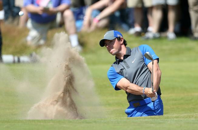 Rory McIlroy of Northern Ireland plays out of a bunker on the 16th hole during the first day of the British Open at the Royal Liverpool golf club in Hoylake, England, on Thursday, July 17, 2014.