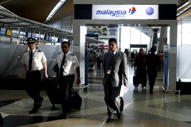 Malaysia Airlines flight crews arrive at Kuala Lumpur International Airport in Sepang, Malaysia, on Friday, July 18, 2014. The Malaysia Airlines Boeing 777-200 that was shot down over war-torn eastern Ukraine on Thursday was carrying 298 people from at least nine countries.
