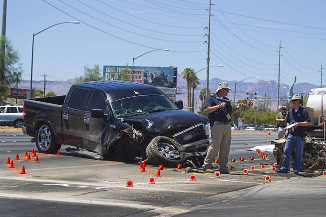 Metro Police investigators take measurements at a fatal accident on Sahara Avenue near Valley View Boulevard Sunday, July 20, 2014. A man who was apparently working on the sidewalk was killed in the accident.