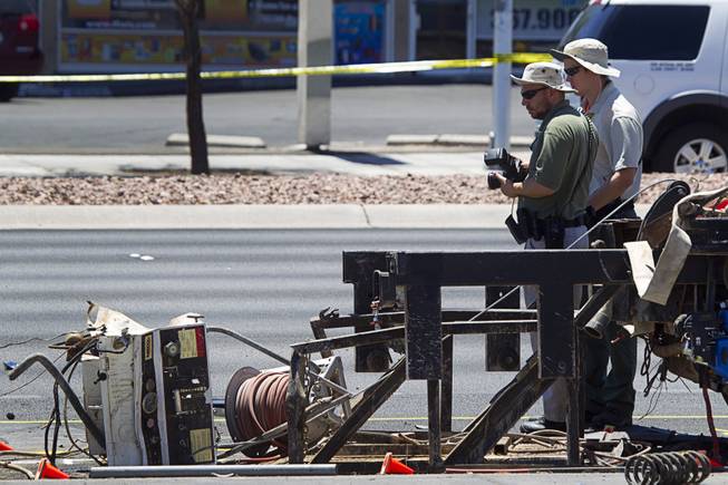 Metro Police crime scene analysts look over a fatal accident scene on Sahara Avenue near Valley View Boulevard Sunday, July 20, 2014. A man who was apparently working on the sidewalk was killed in the accident.