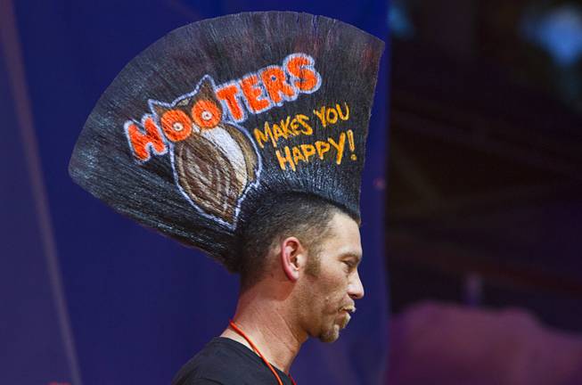"Mohawk Man" Chris Wallingford displays a Hooters ad on his hair during the 2014 Hooters "World-Wide Wing Eating Championship" at the Hard Rock pool Tuesday, July 22, 2014.