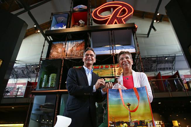 Museum of History and Industry Executive Director Leonard Garfield accepts a donation Tuesday, July 22, 2014, in Seattle of the first legal recreational marijuana purchase in Seattle from Deb Green, right, who made the purchase at Cannabis City on July 8. 