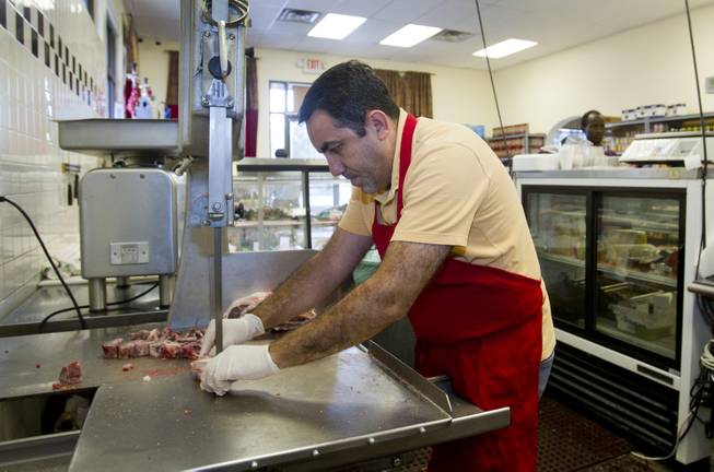 Abdul Nasser Karouni cuts meat at the Afandi Restaurant and Market, 5181 W. Charleston Blvd., Tuesday, July 15, 2014. His wife was granted citizenship over a year ago but Abdul is still waiting. STEVE MARCUS