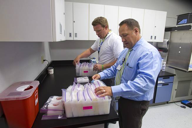 Brent Bergquist, right, director of ocular services at the Nevada Donor Network, and eye technician Kelby Koop go through donated tissue at the Network offices Tuesday, July 22, 2014.